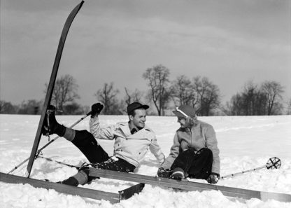 Couple sitting in snow with skis