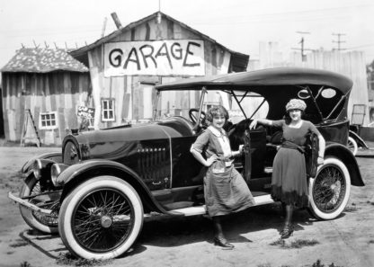 Two woman with car outside garage